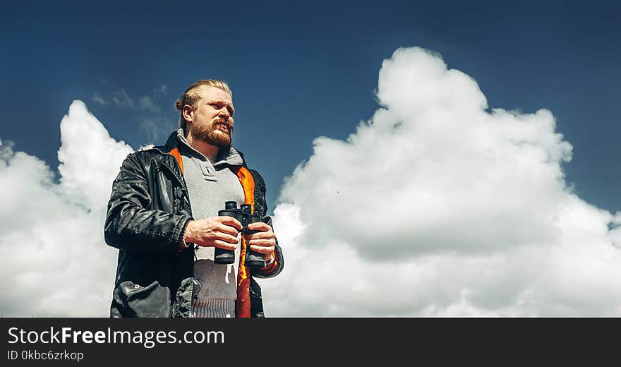 Travel Search Concept. Hiking Man With Beard Holds Binoculars In