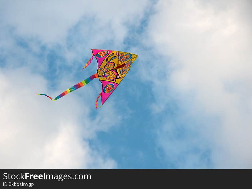 A big colorful kite in the blue sky with clouds. A big colorful kite in the blue sky with clouds