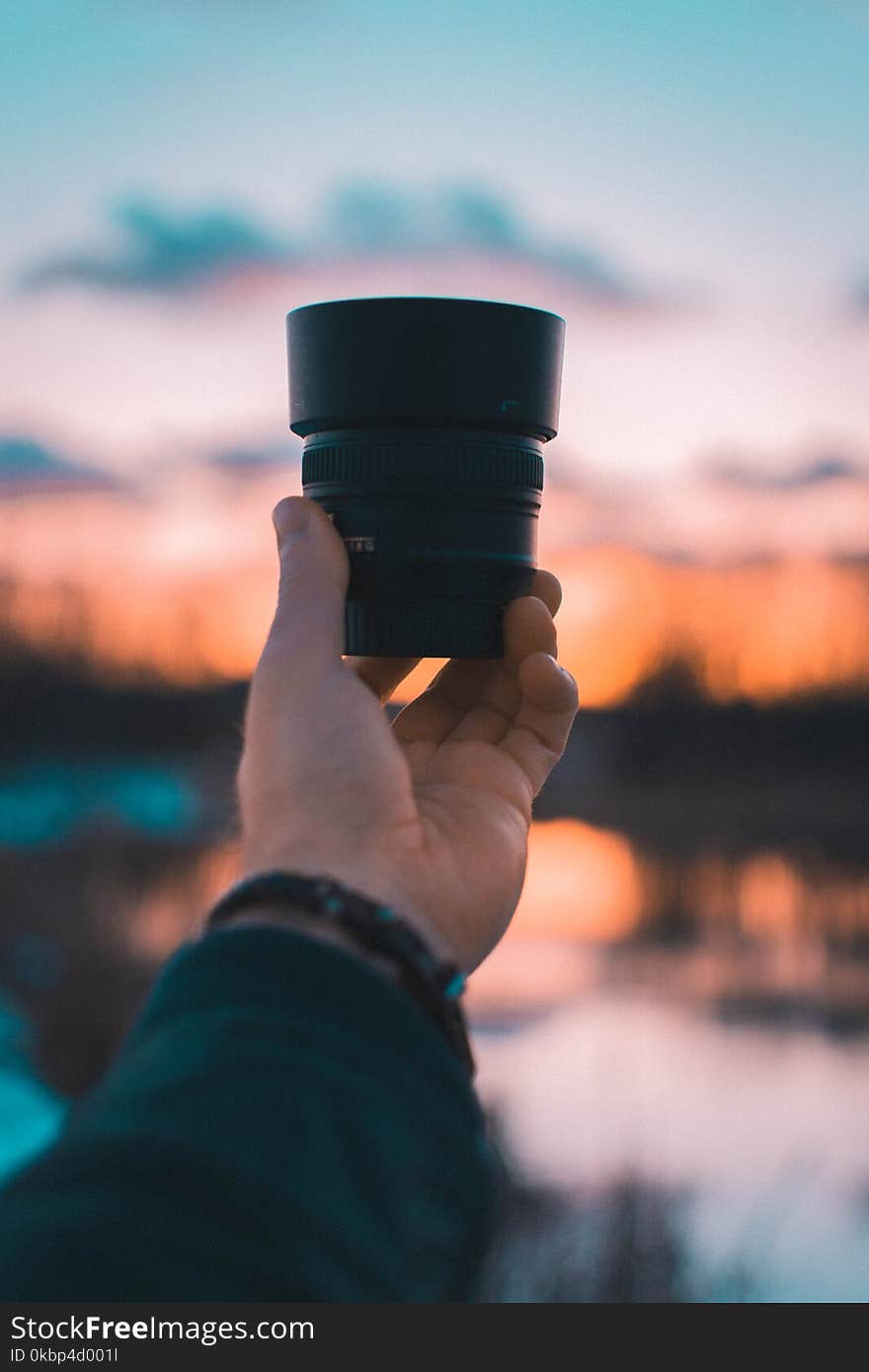 Close-Up Photography of a Person Holding Camera Lens