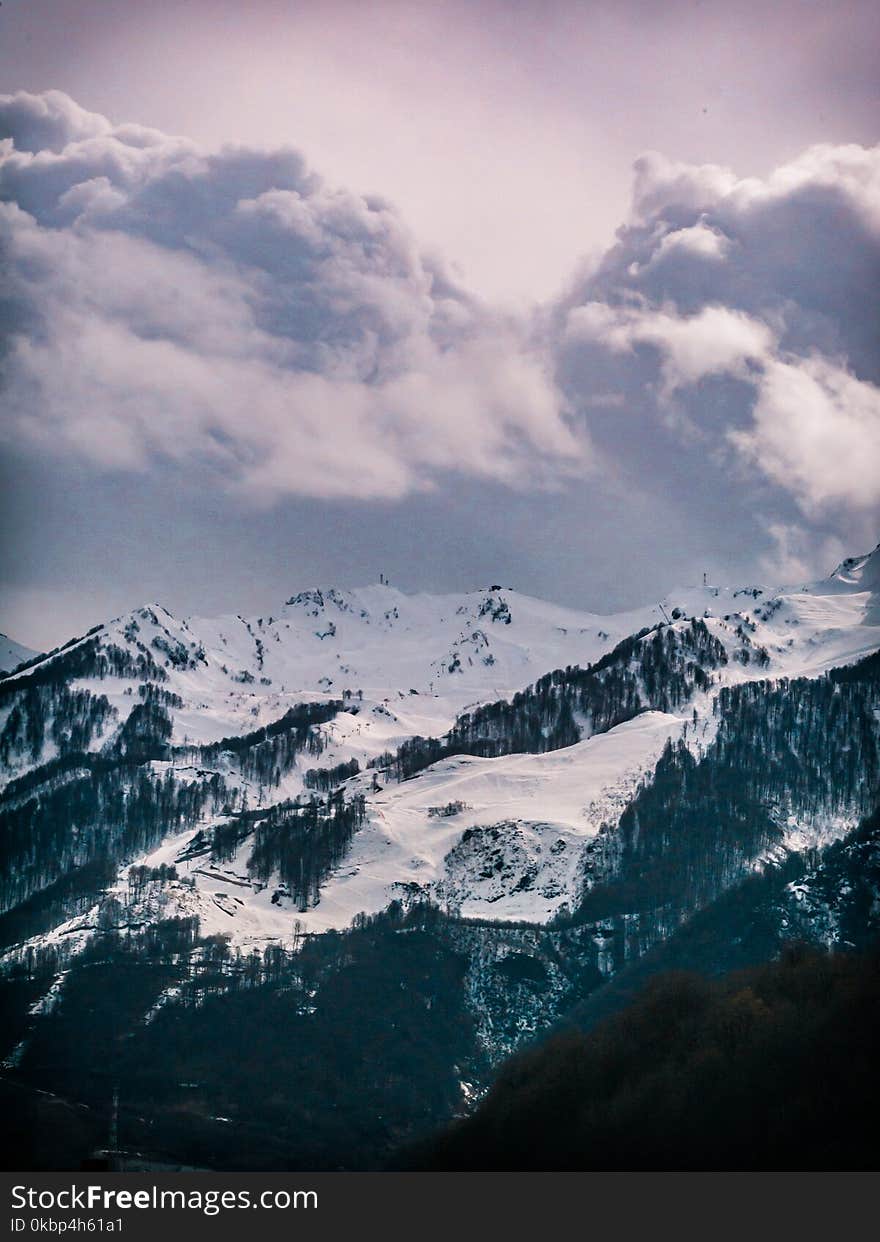 Photography of Snow Capped Mountain Under Cloudy Sky