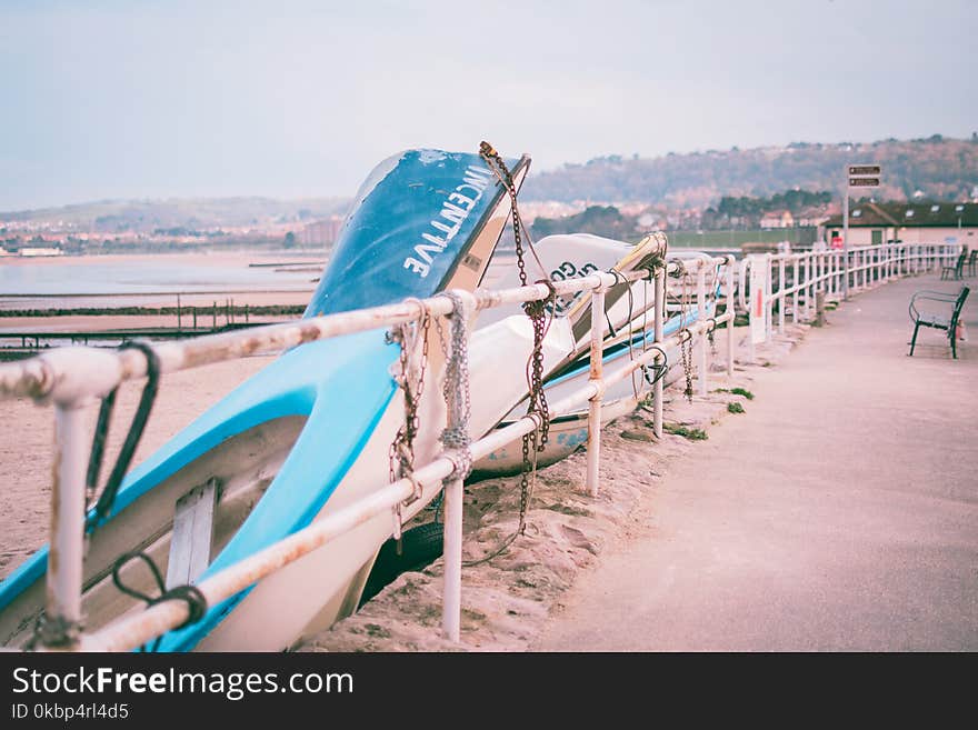 Photo of White and Blue Boats Beside White Railings