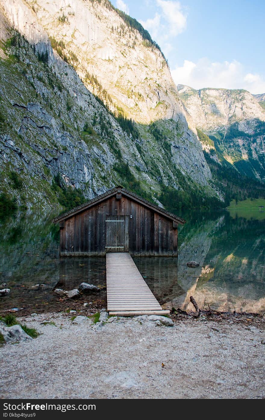 Brown Wooden Dock Near Rocky Cliff