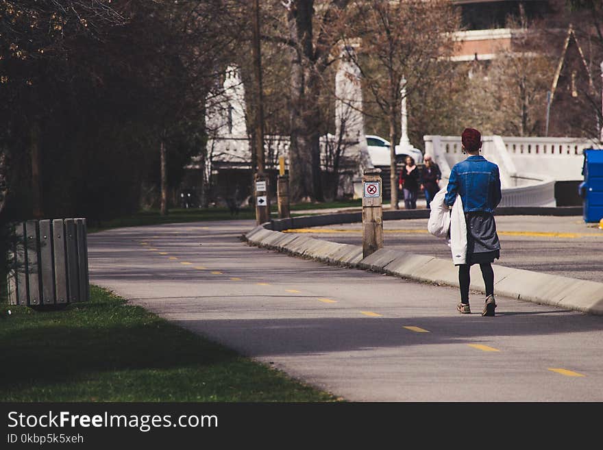 Woman Wearing Blue-washed Denim Jacket Walking On Street