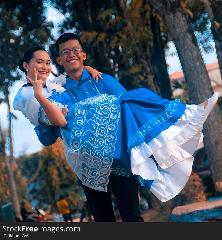 Man Wearing Blue Button-up Shirt Carrying Woman