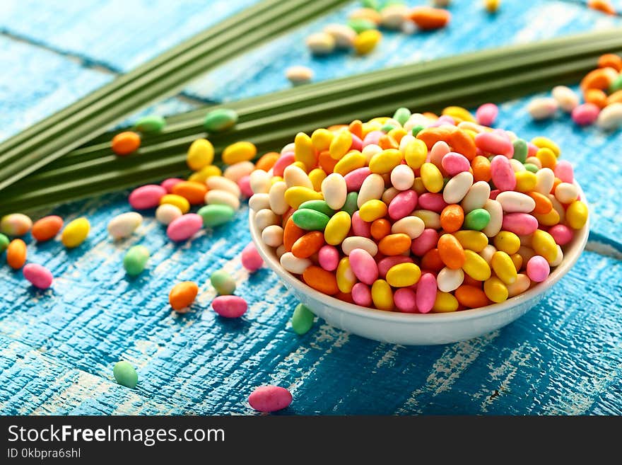 Different colors Indian sweet made of sugar coated cumin seeds.served in bowl.on a rustic background. Different colors Indian sweet made of sugar coated cumin seeds.served in bowl.on a rustic background.