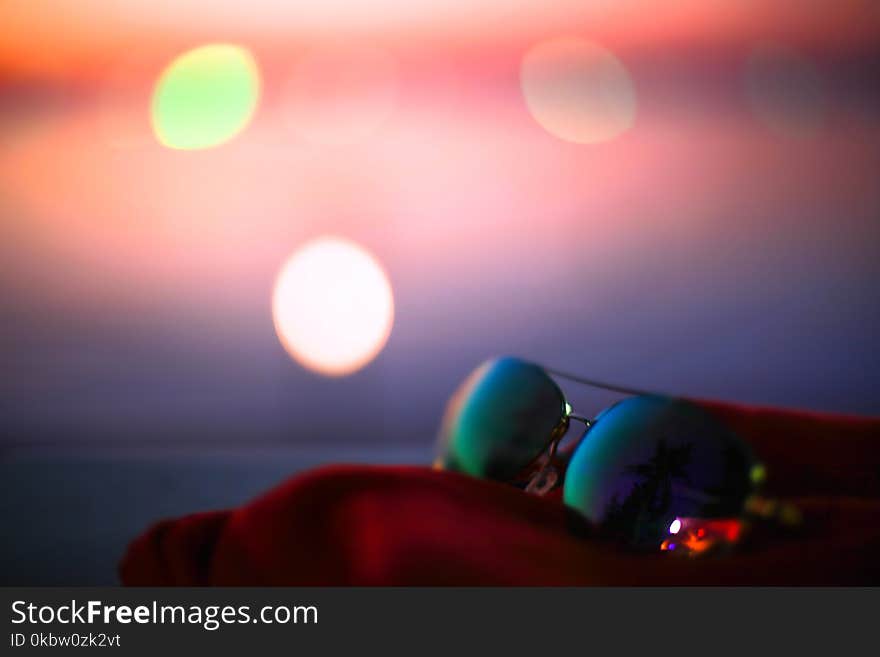 Summer poster with sunglasses, palms and bokeh effects. Blurred sunset beach background.