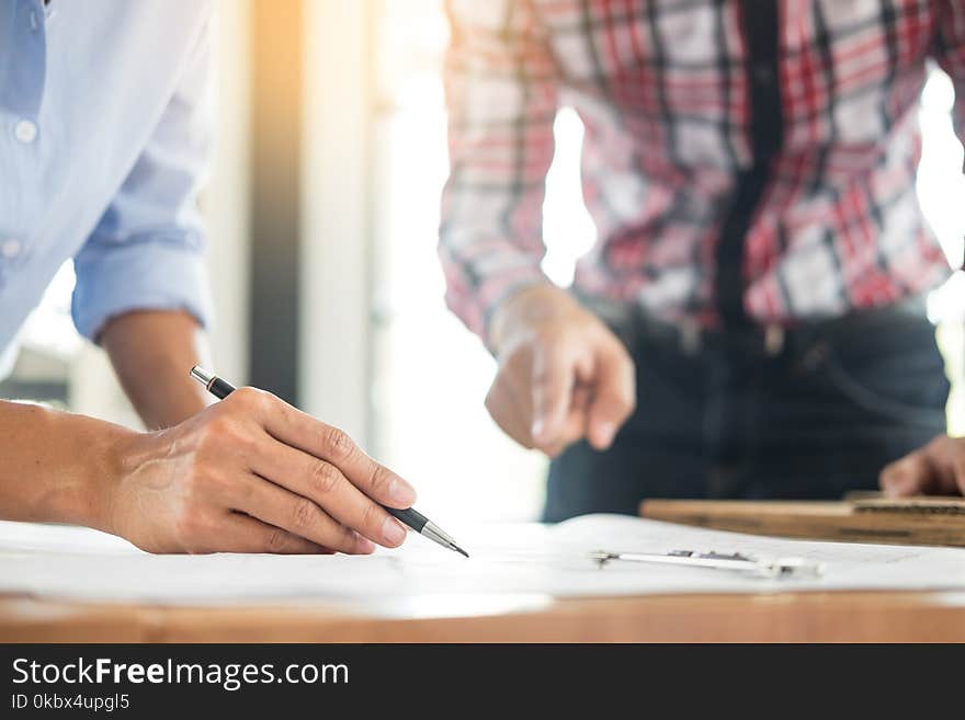 Close-up Of Person`s engineer Hand Drawing Plan On Blue Print with architect equipment, Architects discussing at the table, team work and work flow construction concept.