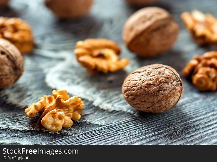 Walnuts and kernels in box on wooden backgound. Close-up and selective focus. Walnuts and kernels in box on wooden backgound. Close-up and selective focus