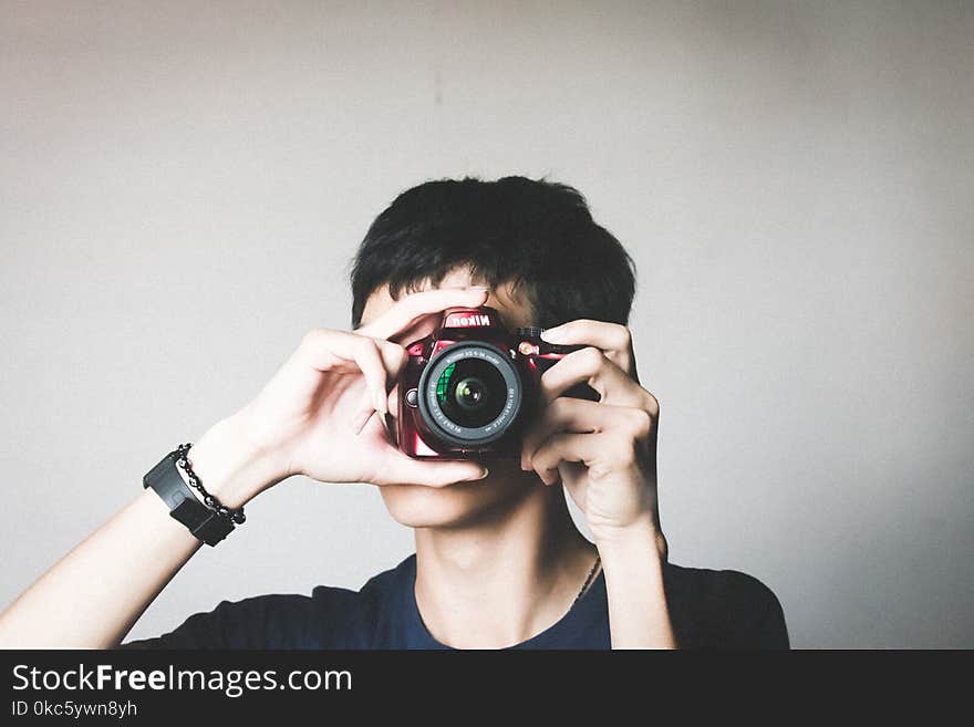 Man in Black Crew-neck Shirt Using Red Bridge Camera