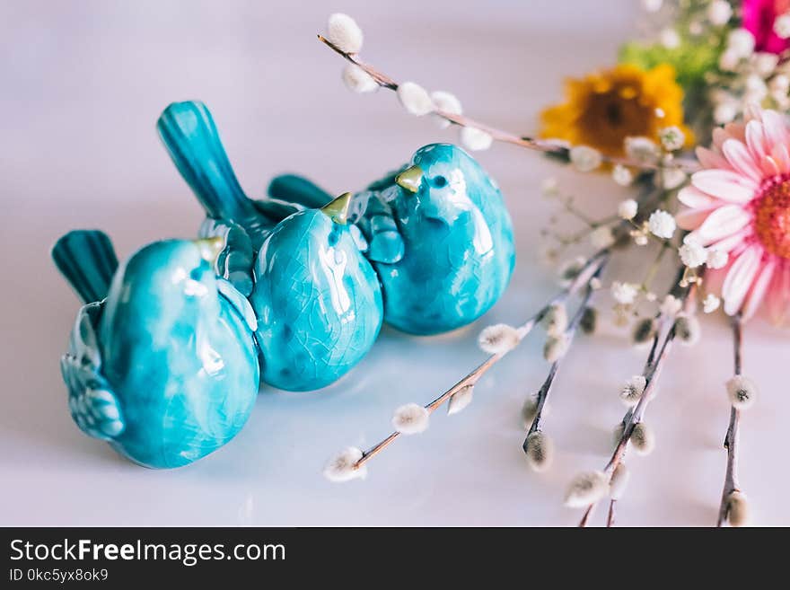 Three Blue Ceramic Bird Decors Beside Pink Flower