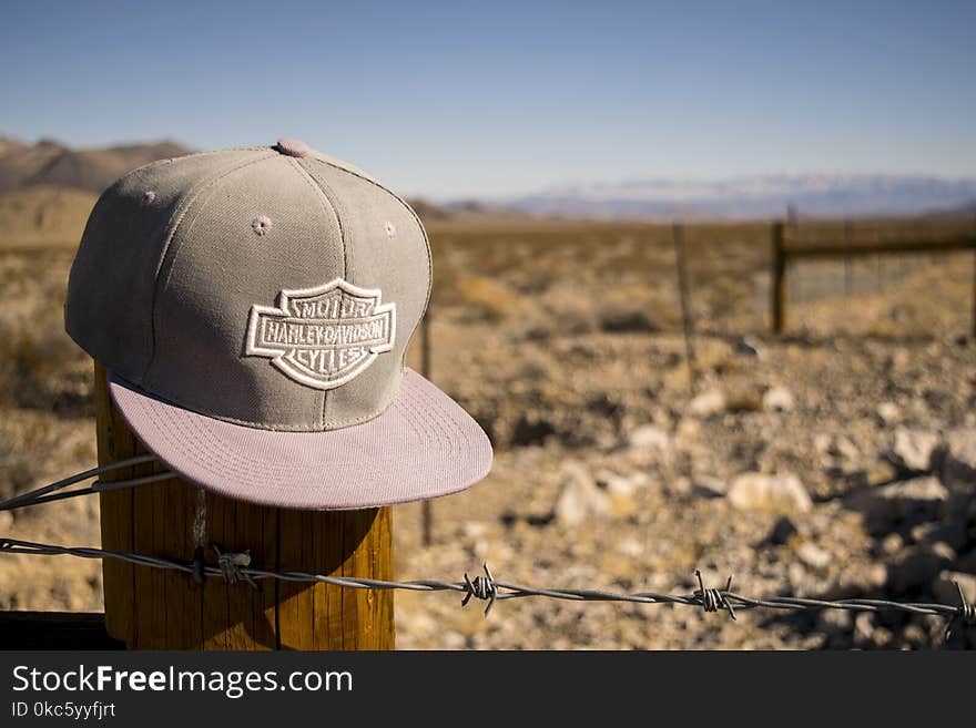 Gray Harley-davidson Motorcycles Flat-brimmed Cap Hanged on Brown Wooden Fence With Gray Barb Wires