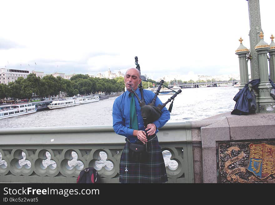 Person Playing Instrument on Bridge