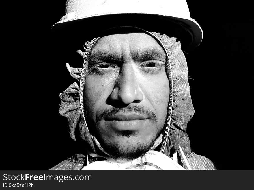 Grayscale Photograph of Man Wearing Hooded Top and Hard Hat