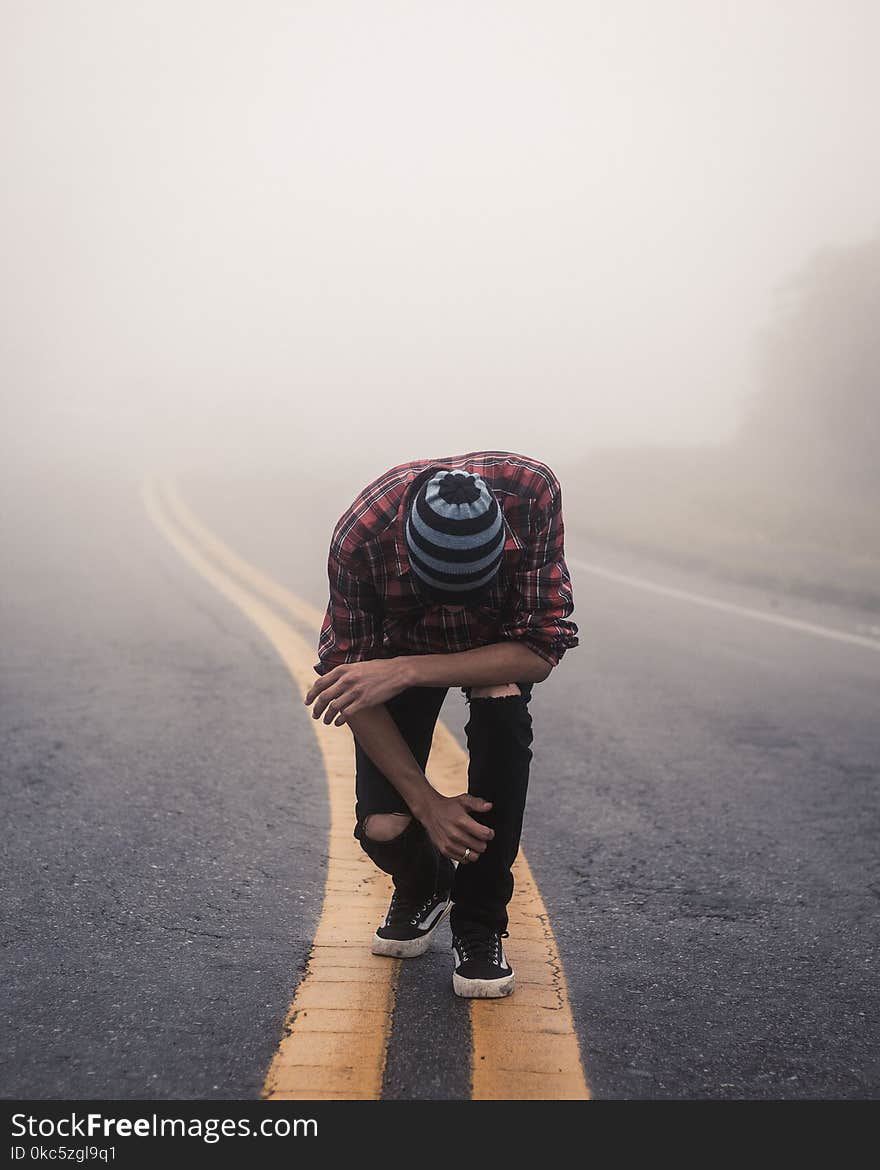 Man Wearing Red Plaid Shirt Standing in Center Road