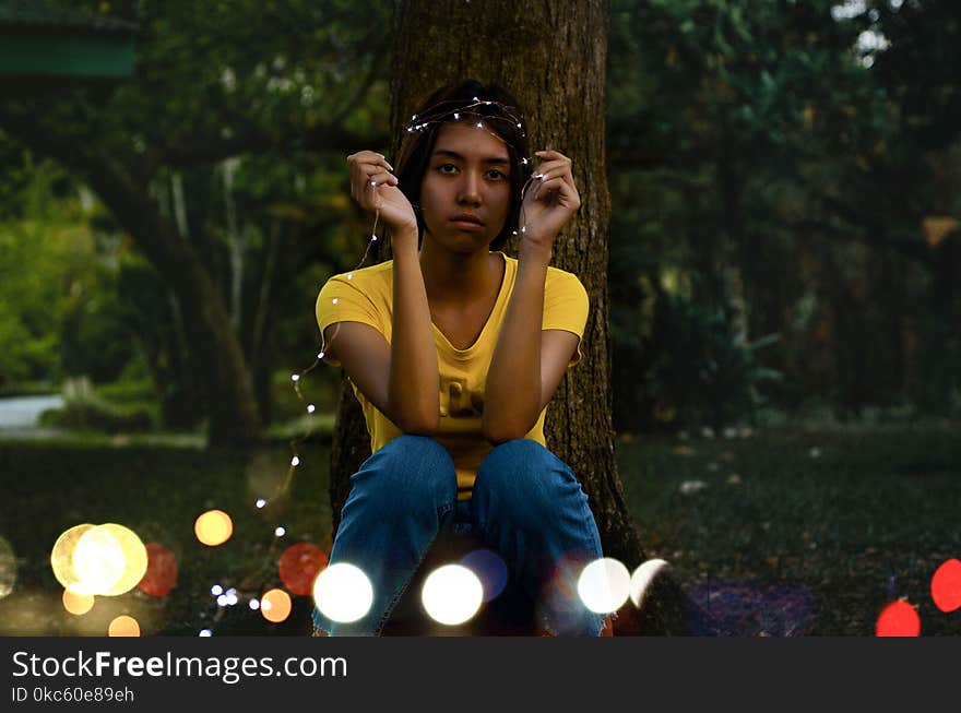 Girl in Yellow Top Sitting Beside Tree