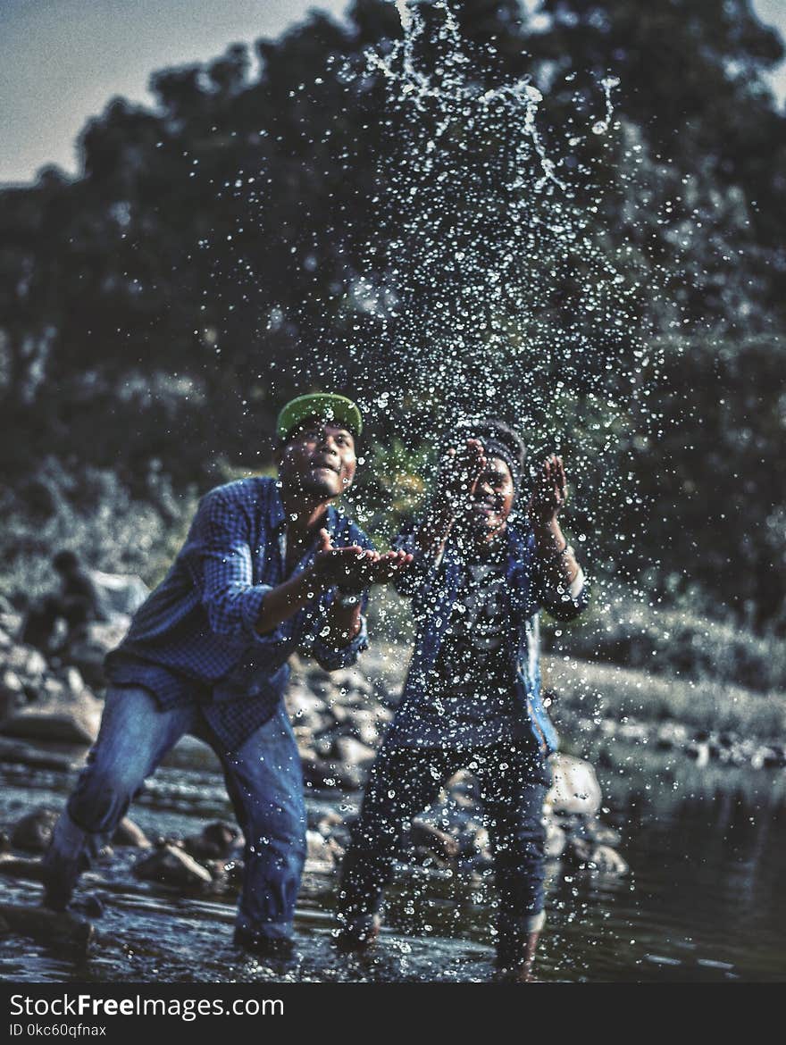 Two Men Playing With Water in Lake