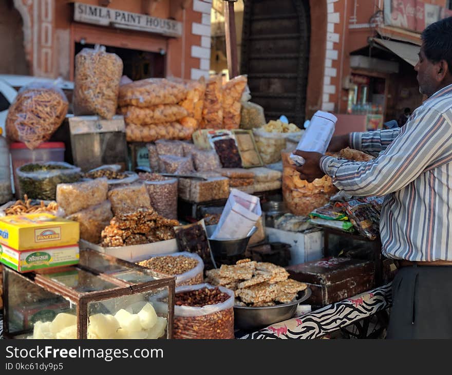 Man In Long-sleeved Shirt Standing Beside Food Stall