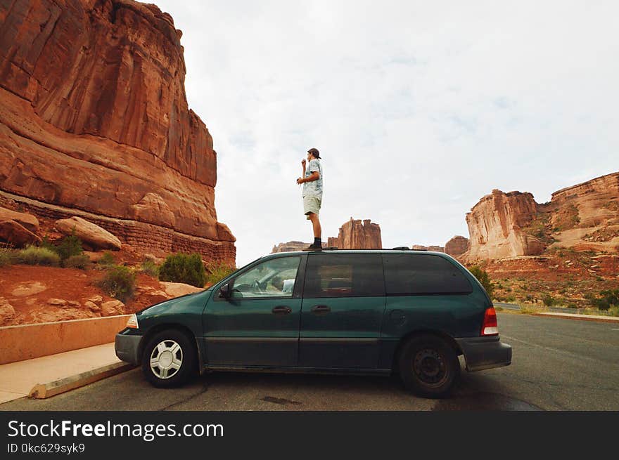 Man Standing On Green Mini Van