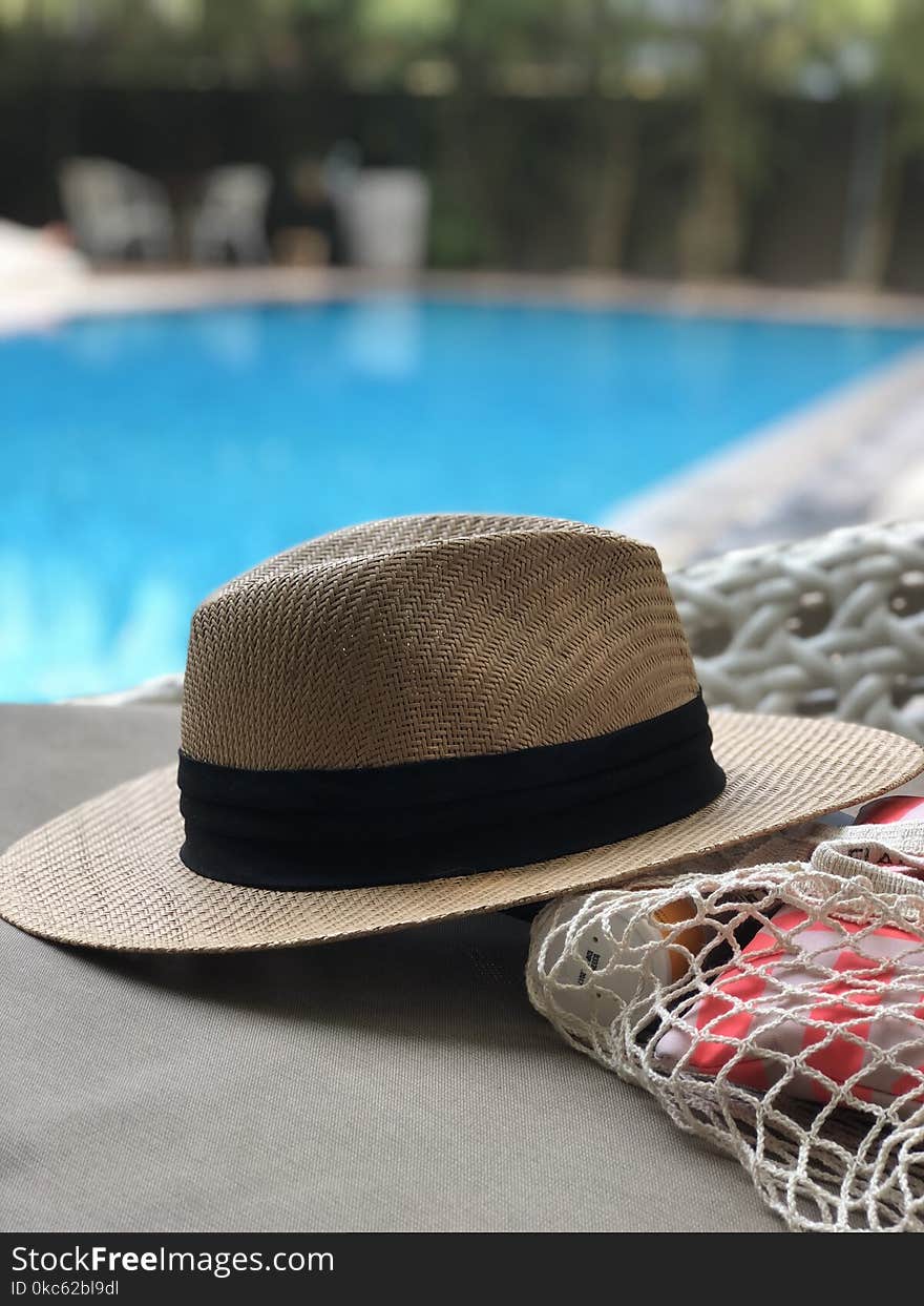 Beige And Black Hat Near Swimming Pool