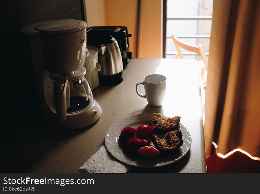 White Ceramic Mug Beside Ceramic Plate On Table