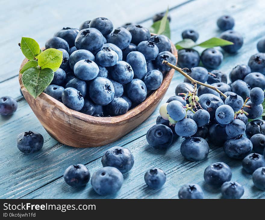 Blueberries in the wooden bowl on the table.