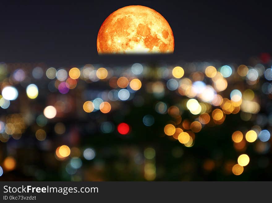 half blood moon and colorful of blur night light over city, Elements of this image furnished by NASA. half blood moon and colorful of blur night light over city, Elements of this image furnished by NASA