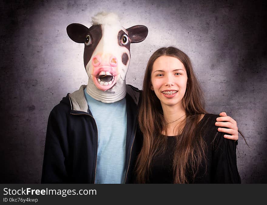 Girl and boy with horse head. Strange couple concept. Studio shot on grey background.