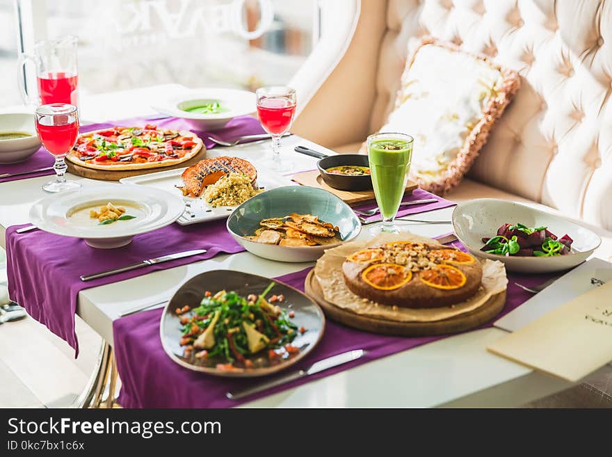 Table In Restaurant With Vegetarian Dishes - Pizza, Salads, Pie And Fresh Natural Drinks.