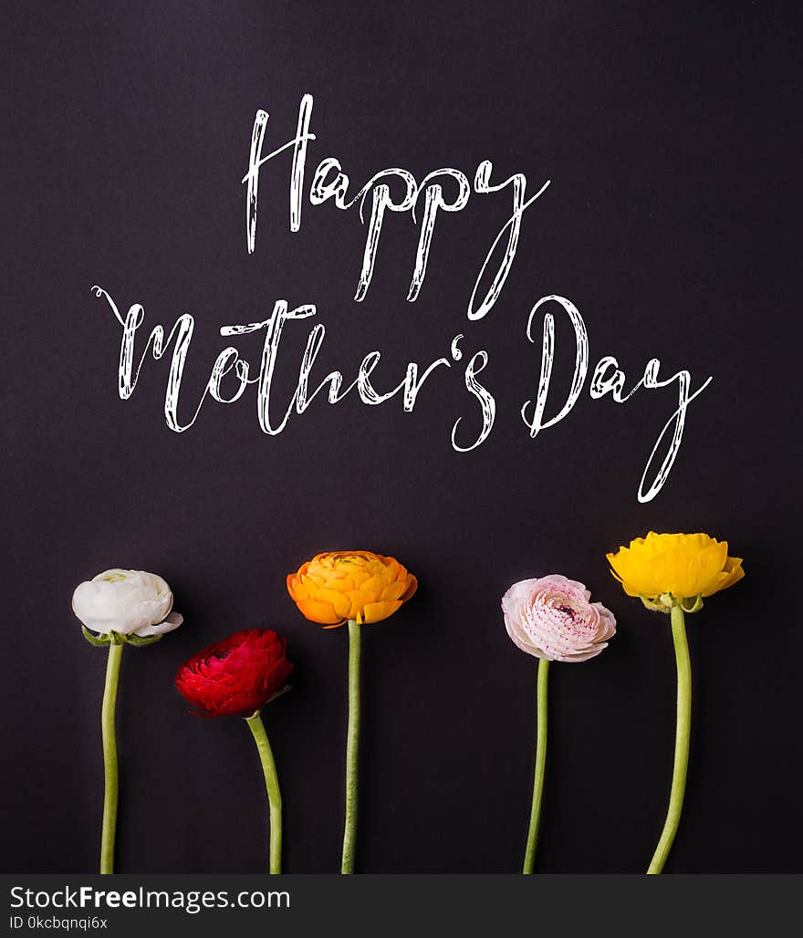 Happy mothers day sign and colored flowers composition. Studio shot on black background. Flat lay. Happy mothers day sign and colored flowers composition. Studio shot on black background. Flat lay.