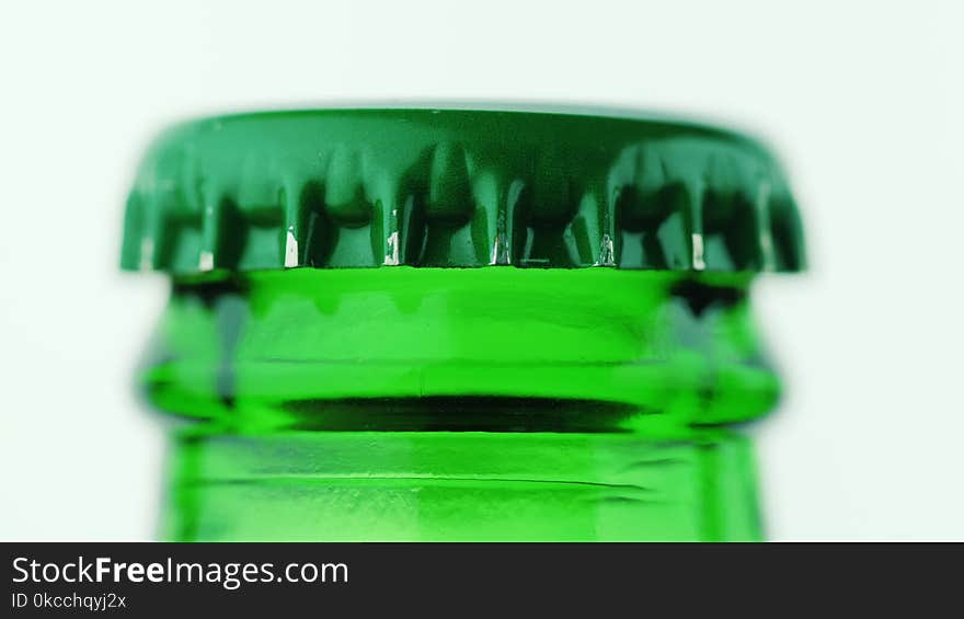 The neck of a bottle of beer is covered with a metal lid. On a white background. The neck of a bottle of beer is covered with a metal lid. On a white background.