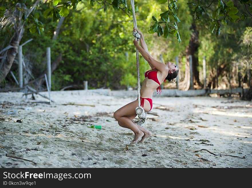 Woman Wearing Red Bikini Swinging