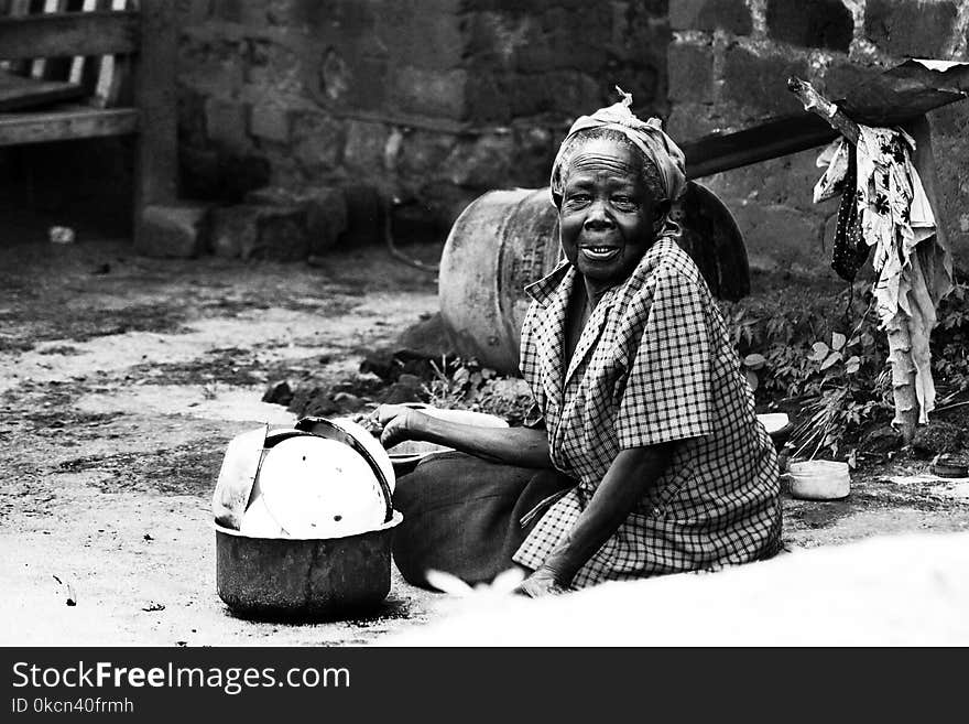 Woman Sitting on Soil Beside Cooking Pot