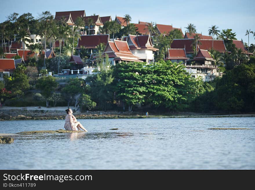 Woman on Rock Beside Body of Water