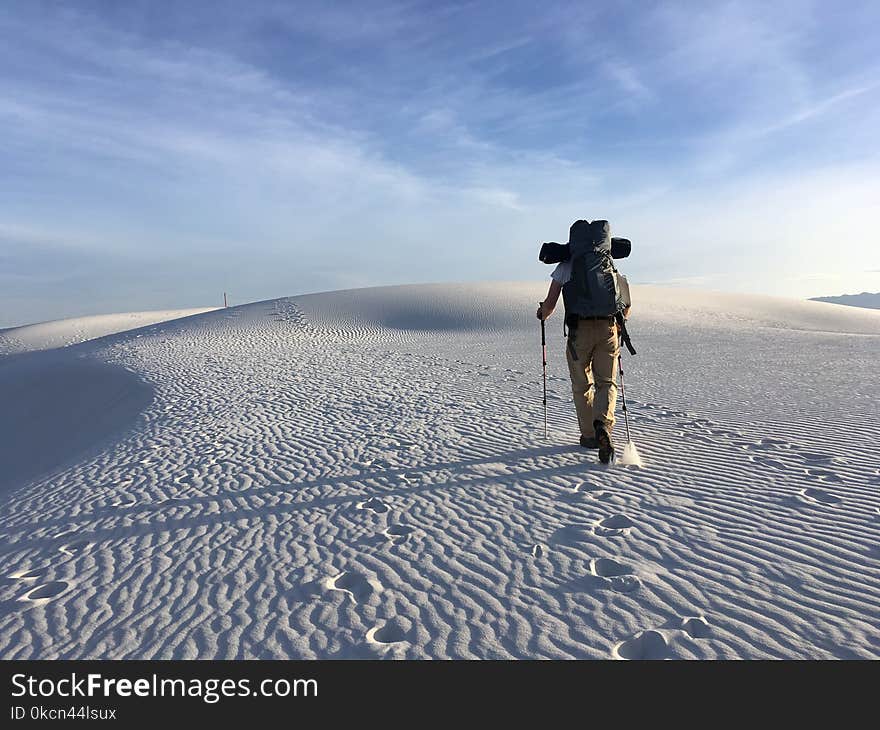 Photo of Man Holding Hiking Poles on Snow Field