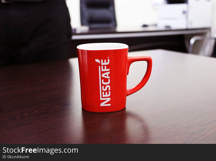 Red and White Nescafe-printed Mug on Brown Wooden Table