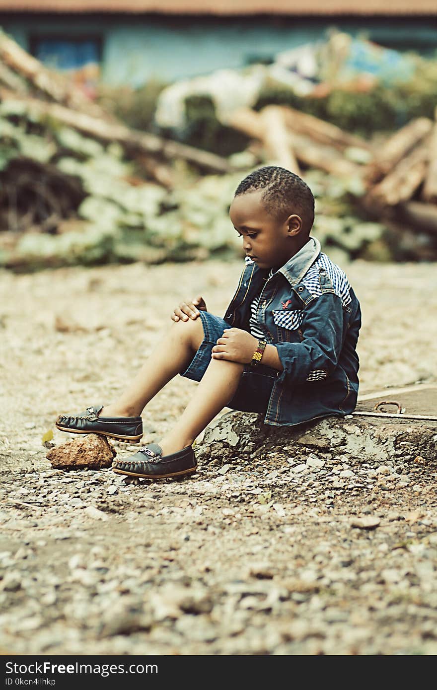 Boy Wearing Denim Jacket and Shorts With Pair of Shoes