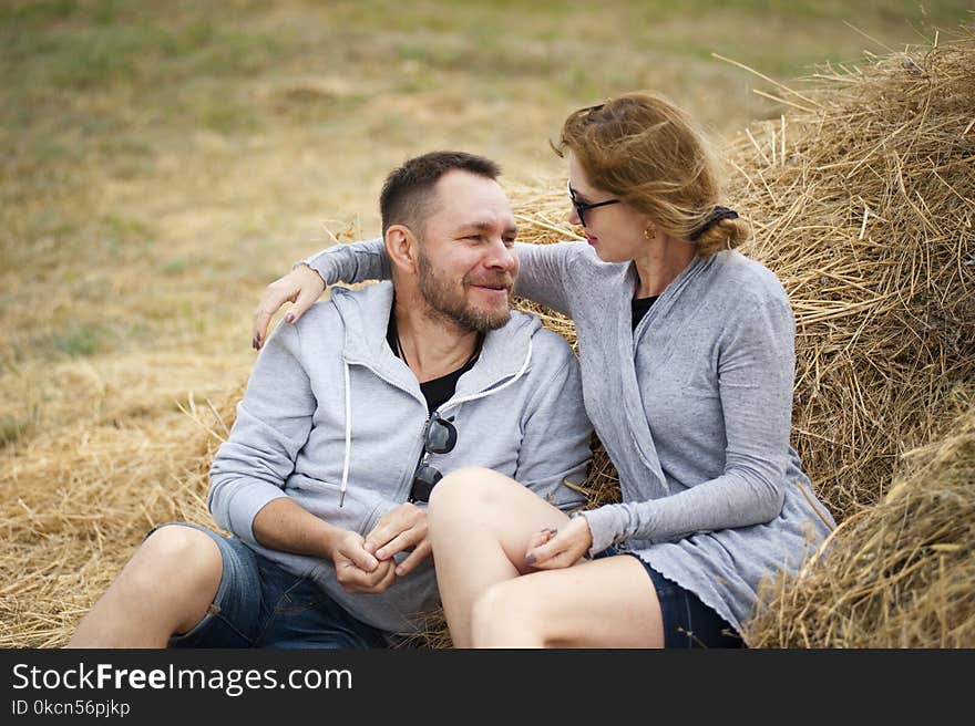 Man and Woman Sitting on Hay