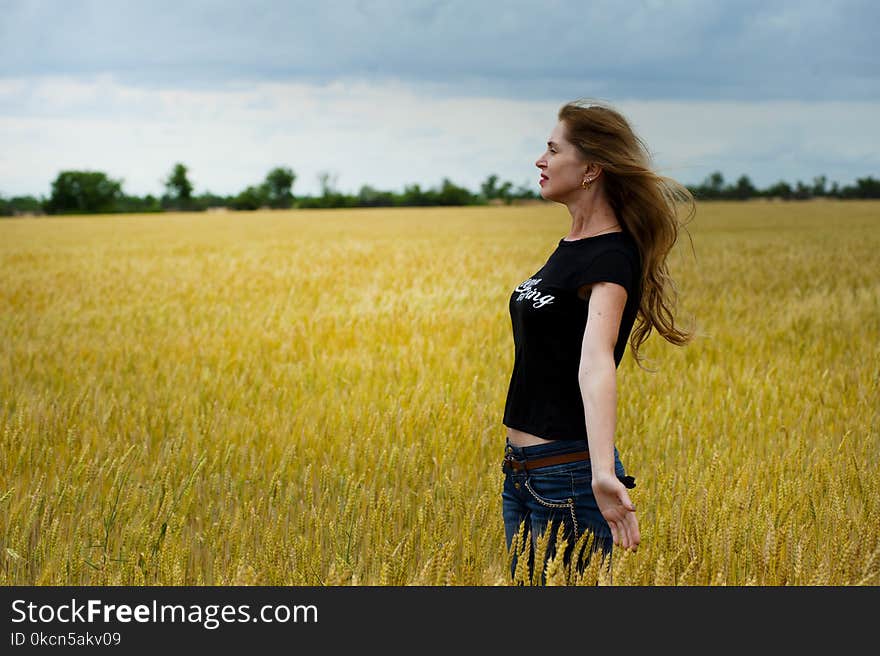 Woman Wearing Black Shirt Surrounded by Grass