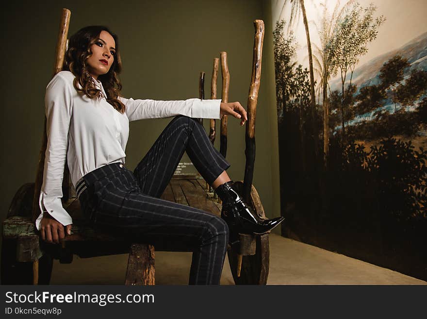 Photo of Woman Sitting on Wooden Chair