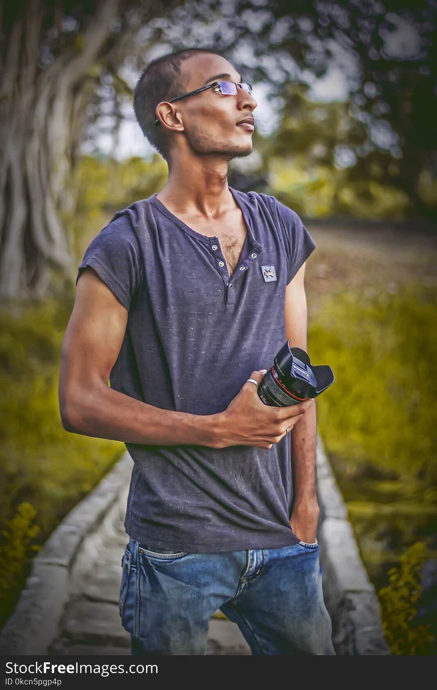 Shallow Focus Photography of Man Wearing Gray T-shirt Holding Dslr Camera Lens