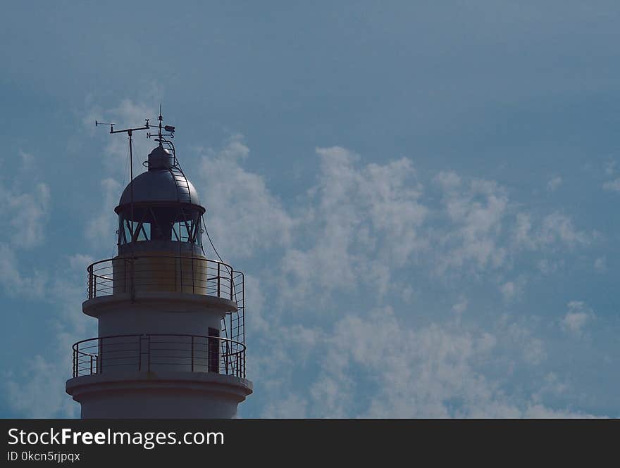 White Lighthouse Under Blue Sky and White Clouds