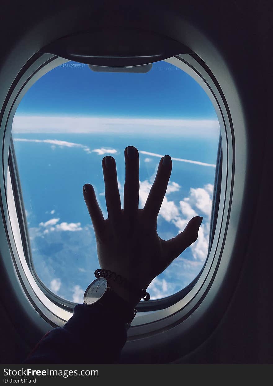 Photography of Person&#x27;s Left Hand Touching an Airplane&#x27;s Window