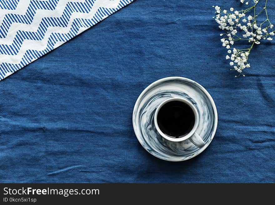 Closeup Photo of Gray and Black Teacup Filled by Coffee With Saucer