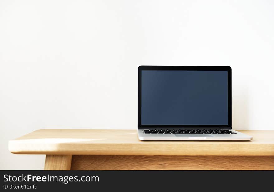 Black and Silver Laptop Computer on Brown Wooden Desk