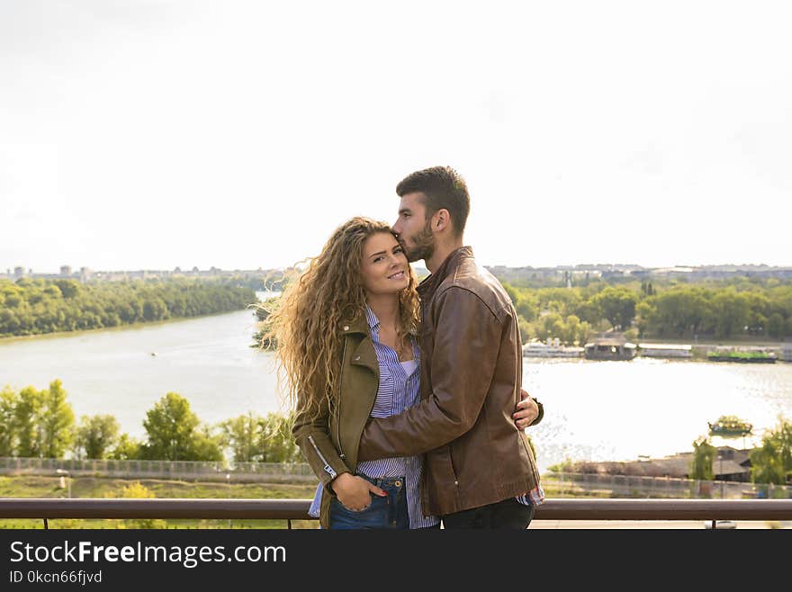 Man Wearing Brown Leather Jacket Hugging Woman Wearing Brown Zip-up Leather Jacket