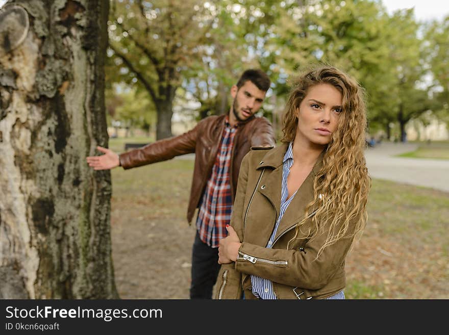 Woman And Man Wearing Brown Jackets Standing Near Tree