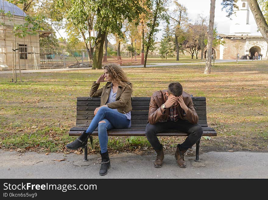 Woman And Man Sitting on Brown Wooden Bench