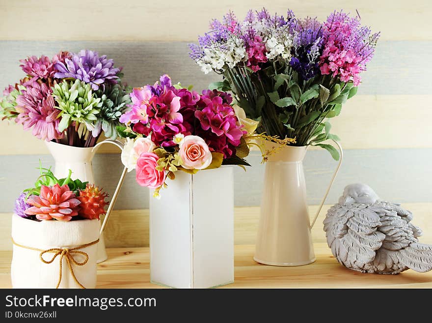 Colorful decoration artificial flower bouquet and bird statue on wooden Shelves