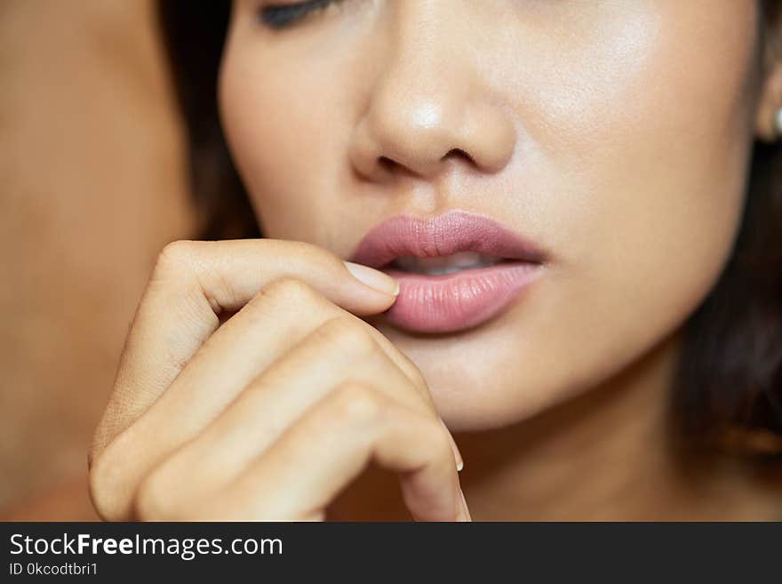 Extreme close-up of sensual young woman with plump lips, blurred background