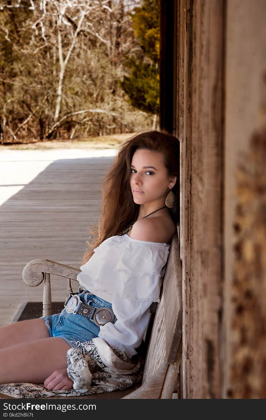 Woman Wearing White Off Shoulder Top Sitting on Bench